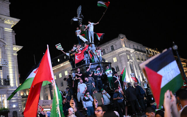Des partisans pro-palestiniens brandissant des drapeaux et des pancartes lors d'une manifestation à Piccadilly Circus, à Londres, le 9 octobre 2023. (Crédit : Daniel Leal/AFP)