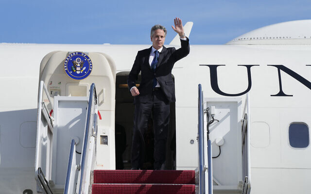 Le secrétaire d'État américain Antony Blinken saluant les passagers d'un avion, le 11 octobre 2023, à la base militaire d'Andrews, dans le Maryland, en route pour Israël. (Crédit : Jacquelyn Martin/POOL/AFP)