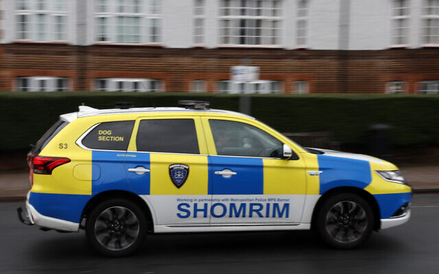 Une voiture du groupe de sécurité privée « Shomrim » passe devant une synagogue à Stamford Hill, au nord de Londres, le 13 octobre 2023, après que le gouvernement britannique a annoncé un financement supplémentaire pour la protection des lieux juifs. (Crédit : Daniel LEAL / AFP)