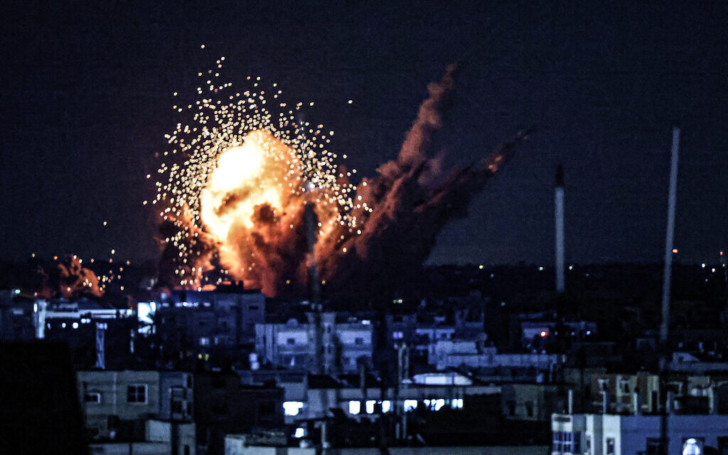 Une boule de feu et de fumée s'élève au dessus d'immeubles pendant une frappe israélienne à Rafah, dans le sud de la bande de Gaza, le 15 octobre 2023. (Crédit : SAID KHATIB / AFP)