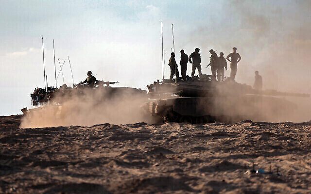 Des soldats et chars israéliens dans un champ près du kibboutz Beeri, dans le sud d'Israël, le 14 octobre 2023. (Crédit : Thomas Coex/AFP)