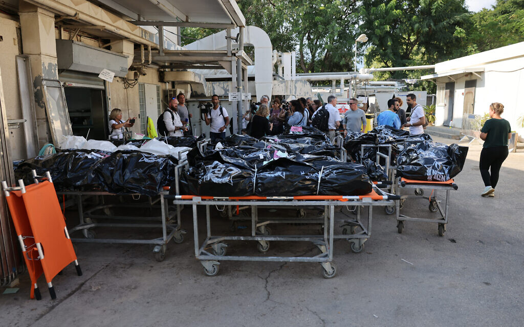Des corps de personnes tuées lors de l'attaque menée par des terroristes du Hamas dans le sud d'Israël attendent d'être identifiés, devant le Centre national de médecine légale de Tel Aviv, le 16 octobre 2023. (Crédit : AHMAD GHARABLI / AFP)