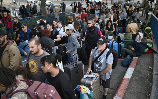 Des citoyens israéliens qui attendent d'être évacués vers Chypre depuis le port de Haïfa, le 16 octobre 2023. (Crédit : Aris MESSINIS / AFP)