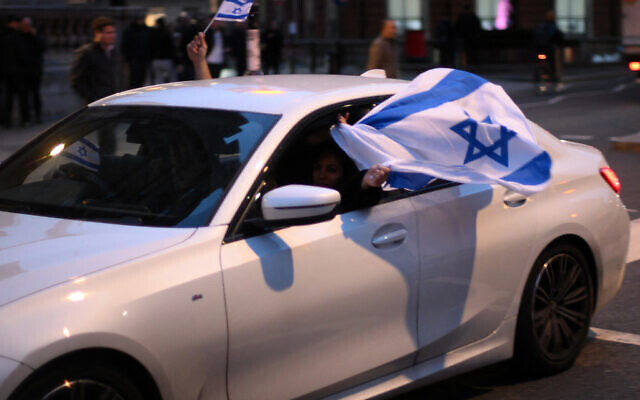 Les manifestants déploient des drapeaux israéliens aux abords du siège de la BBC à Londres, le 16 octobre 2023. (Crédit : Daniel LEAL / AFP)