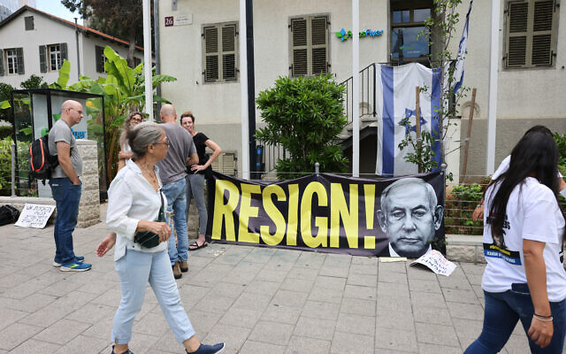 Une banderole sur laquelle on peut lire "Démission !" à côté de l'image du Premier ministre israélien Benjamin dans la ville de Tel Aviv le 18 octobre 2023, en pleine guerre contre le Hamas. (Crédit : AHMAD GHARABLI / AFP)