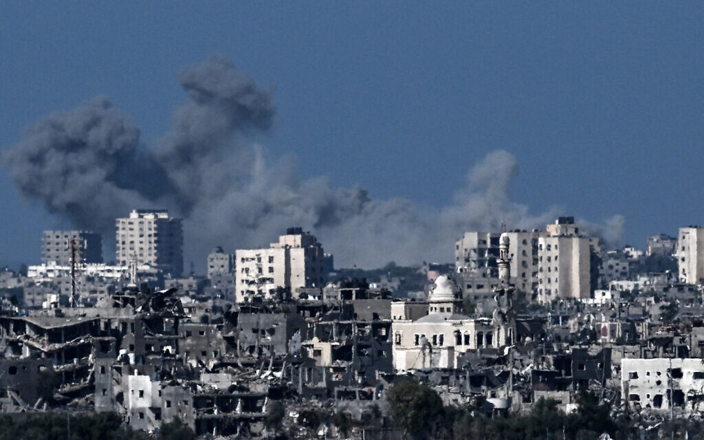 De la fumée s'élevant derrière des bâtiments détruits dans la partie nord-ouest de l'enclave palestinienne lors de frappes israéliennes sur le Hamas, le 21 octobre 2023 (Crédit : Aris Messinis/AFP)