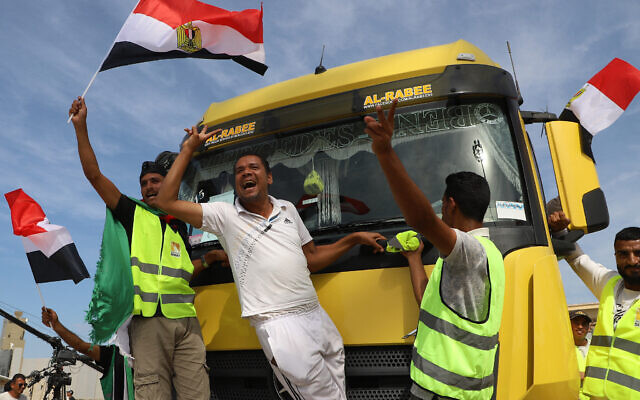 Des travailleurs humanitaires égyptiens célébrant le passage d'un camion d'aide vers l'Égypte par le poste frontière de Rafah avec la bande de Gaza, le 21 octobre 2023. (Crédit : Kerolos Salah/AFP)