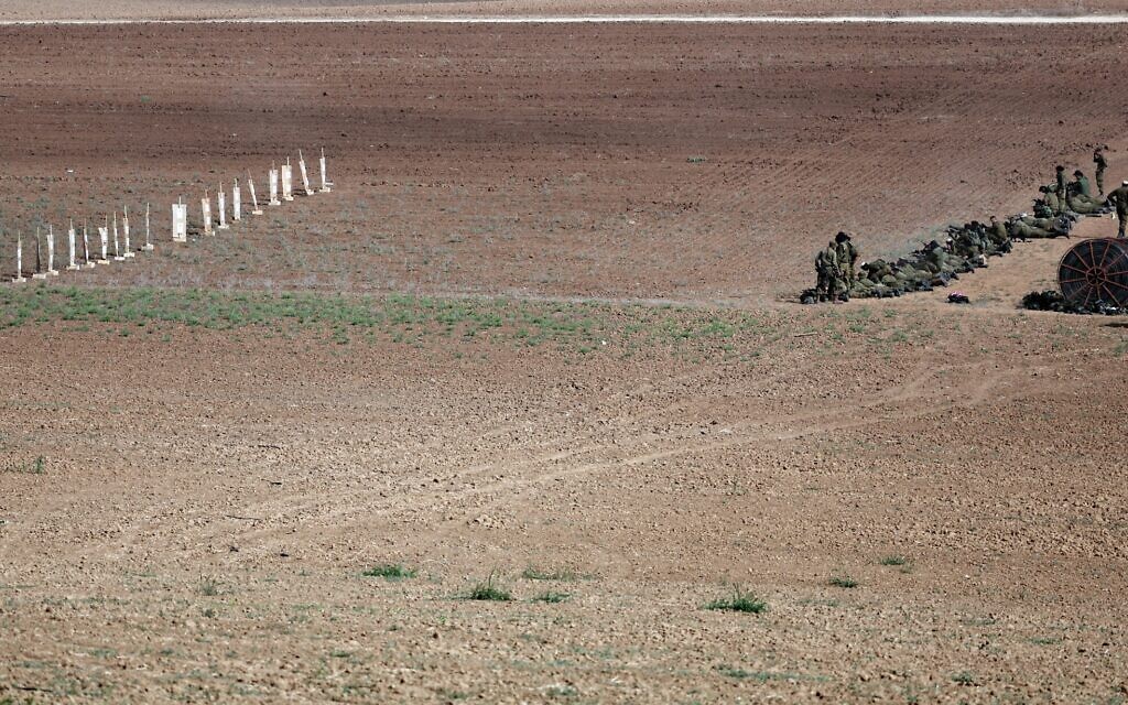 Des soldats israéliens s'entraînant à tirer avec leurs fusils dans un champ près de Sderot, le 23 octobre 2023. (Crédit : Thomas COEX/AFP)