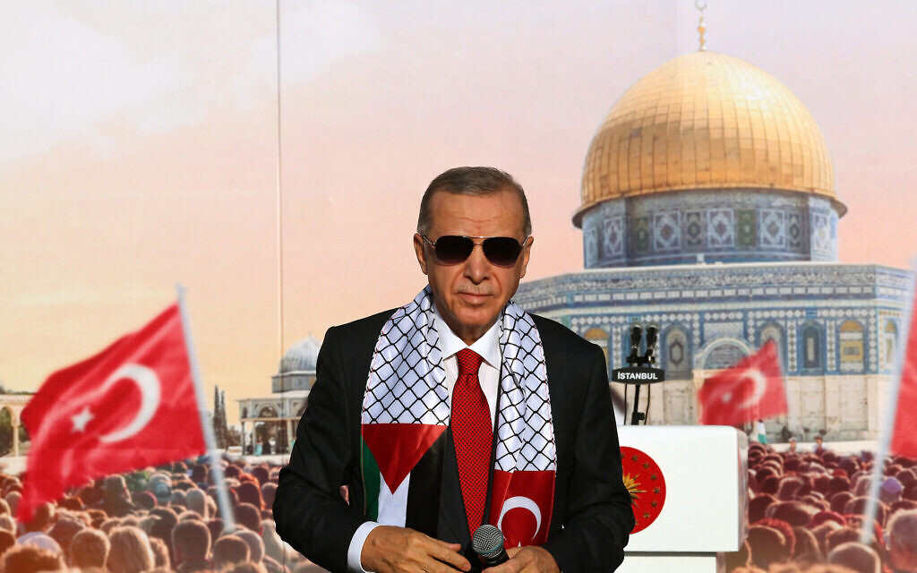 Le président turc Recep Tayyip Erdogan, portant une écharpe avec les drapeaux palestinien et turc, sur scène lors d'un rassemblement organisé par son parti au pouvoir, l'AKP, en solidarité avec les Palestiniens de Gaza, à Istanbul, le 28 octobre 2023. (Crédit : Bureau de presse de la présidence turque/AFP)