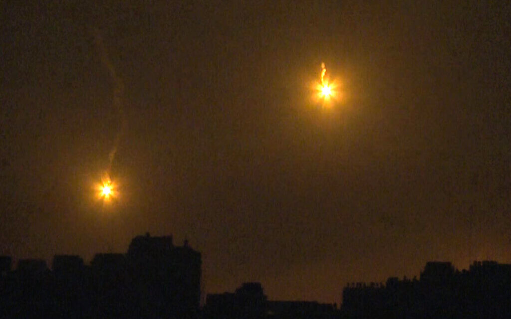 Cette image tirée d'une séquence TV de l'AFP montre des fusées éclairantes tirées par l'armée israélienne illuminant le ciel nocturne au-dessus de la ville de Gaza, le 27 octobre 2023. (Crédit : Yousef Hassouna/AFP)