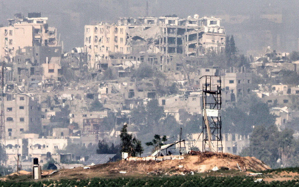 Une tour de guet et des bâtiments lourdement endommagés derrière dans la bande de Gaza, sur une photo prise depuis une position le long de la frontière avec la bande de Gaza près de Sderot, dans le sud d'Israël, le 27 octobre 2023. (Crédit : Jack Guez/AFP)