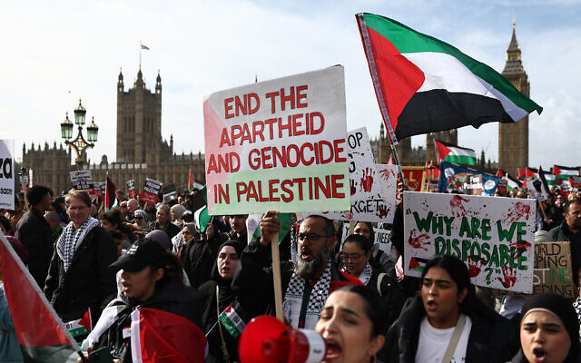 Des manifestants brandissant des pancartes et des drapeaux palestiniens lors d'une "Marche pour la Palestine" pour demander un cessez-le-feu dans la guerre entre Israël et le Hamas, à Londres, le 28 octobre 2023. (Crédit : Henry Nicholls/AFP)