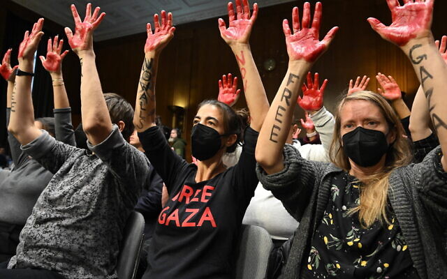 Des manifestants affichant le message "Free Gaza" levant les mains en l'air lors d'une audition de la commission des crédits du Sénat pour examiner la demande supplémentaire de sécurité nationale, sur la colline du Capitole, à Washington, le 31 octobre 2023. (Crédit : Saul Loeb/AFP)