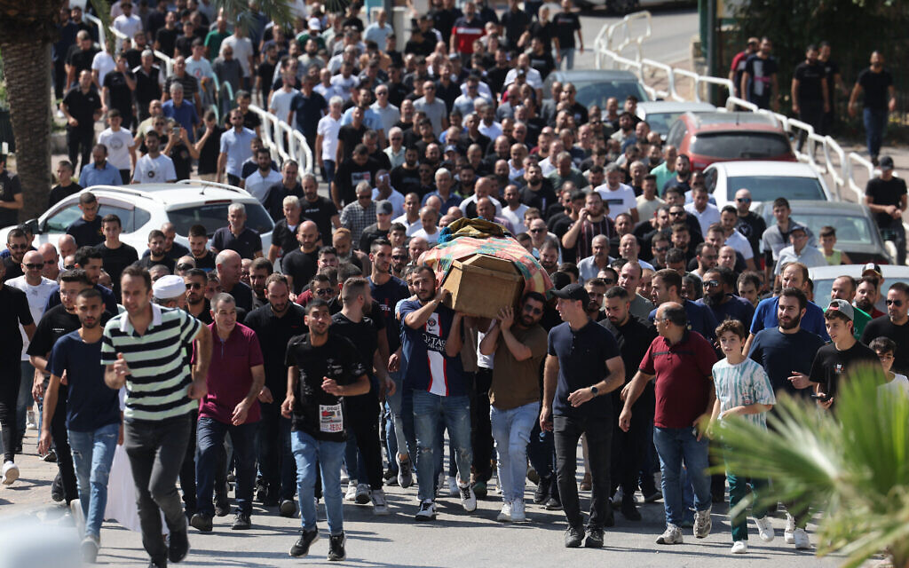 Des personnes endeuillées portent le cercueil de Majed Ibrahim, décédé des suites de blessures subies après une attaque à la roquette dans la ville arabe israélienne d'Abu Ghosh le 9 octobre, lors de ses funérailles dans la ville, près de Jérusalem, le 14 octobre 2023. (Crédit :  AHMAD GHARABLI / AFP)