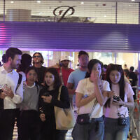 Des visiteurs évacuant un centre commercial à Bangkok, en Thaïlande, le 3 octobre 2023. (Crédit : Sakchai Lalit/AP Photo)
