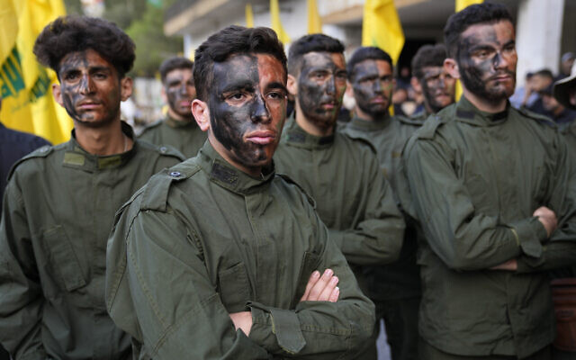 Des combattants du Hezbollah assistant à la procession funéraire de leurs deux camarades tués par des tirs israéliens, dans le village de Kherbet Selem, au Sud-Liban, le 10 octobre 2023. (Crédit : Hussein Malla/AP Photo)