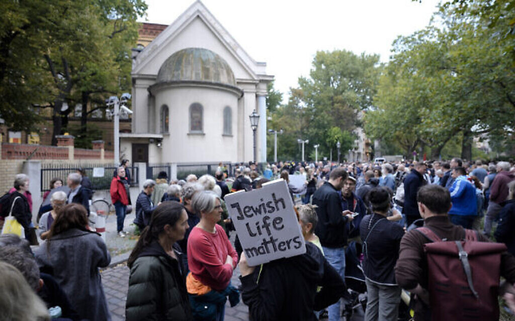 Des centaines de personnes se sont rassemblées devant la synagogue du Fraenkelufer pour prendre part à une veillée à Berlin, en Allemagne, le 13 octobre 2023. (Crédit : Markus Schreiber/AP)