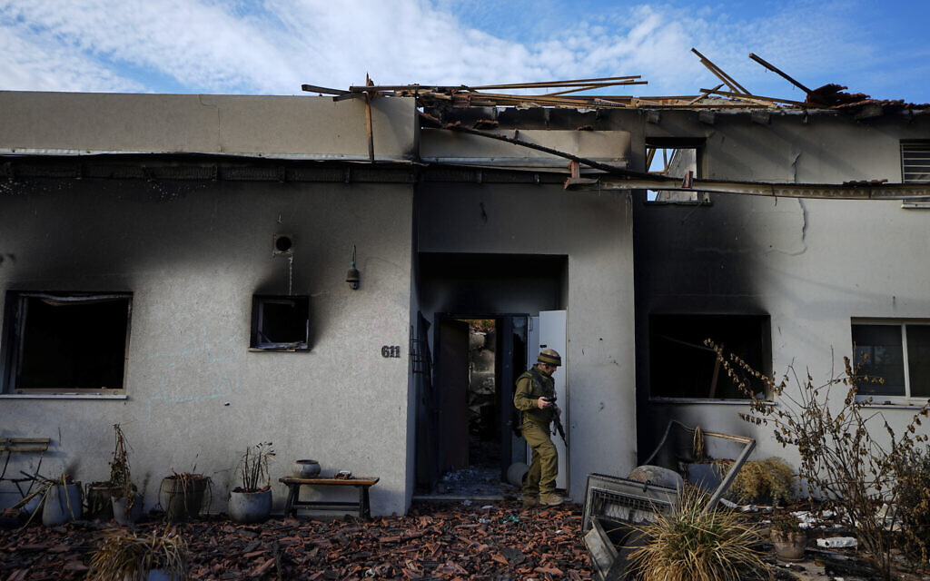 Un soldat israélien inspectant une maison endommagée dans le kibboutz Beeri, en Israël, le 17 octobre 2023. (Crédit : Ariel Schalit/AP/)