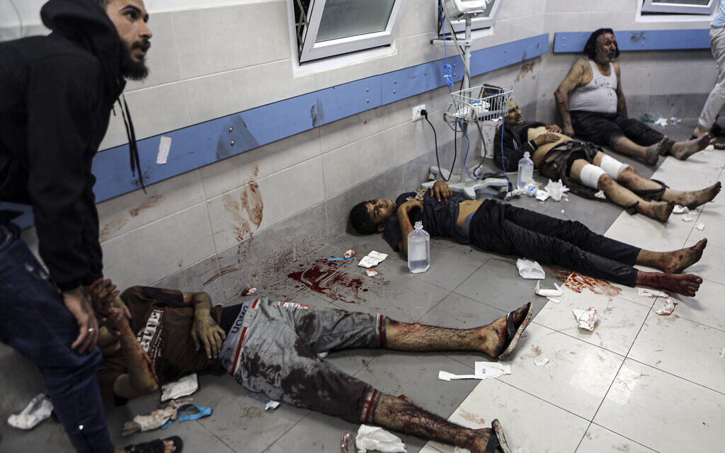 Des Palestiniens blessés allongés sur le sol de l'hôpital al-Shifa dans la ville de Gaza, au centre de la bande de Gaza, après être arrivés de l'hôpital al-Ahli à la suite d'une explosion, le 17 octobre 2023. (Crédit : Abed Khaled/AP)