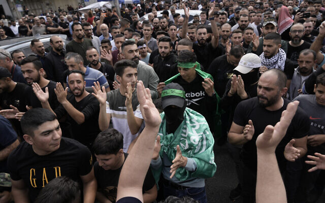 Des manifestants palestiniens brandissant des drapeaux du Hamas et scandent des slogans lors d'une manifestation contre les frappes aériennes israéliennes à Gaza, dans la ville de Naplouse, en Cisjordanie, le 18 octobre 2023. (Crédit : Majdi Mohammed/AP Photo)