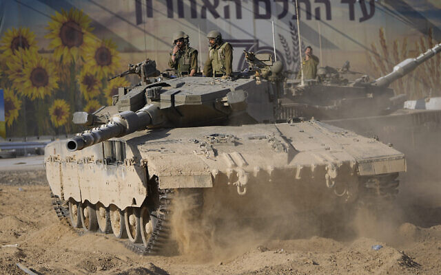 Des soldats israéliens déplaçant un char dans une zone de rassemblement près de la frontière avec la bande de Gaza, dans le sud d'Israël, le 15 octobre 2023. (Crédit : Ohad Zwigenberg/AP Photo)