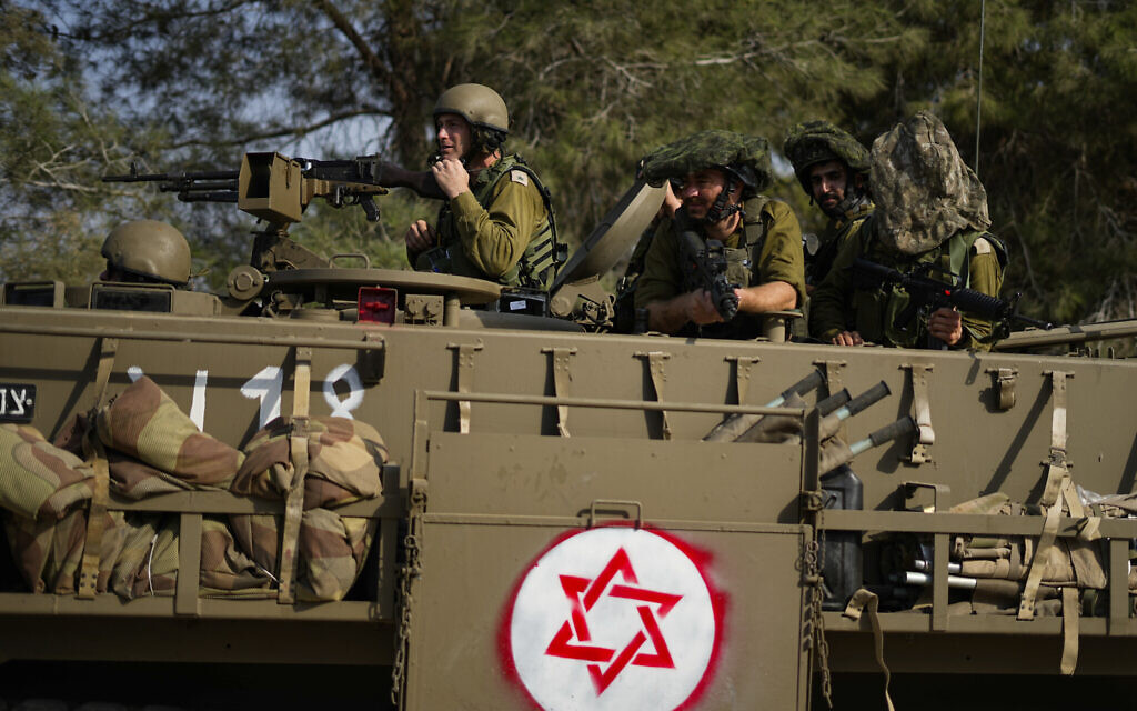 Des soldats israéliens conduisant un véhicule blindé de transport de troupes (APC) près de la frontière avec la bande de Gaza, dans le sud d'Israël, le 22 octobre 2023. (Crédit : Ariel Schalit/AP Photo)