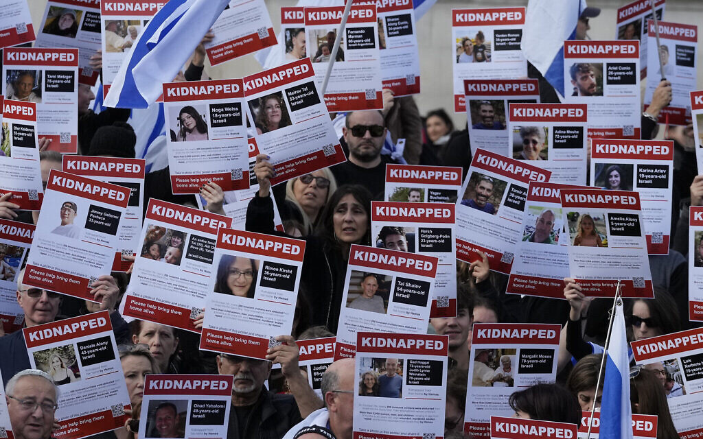 Des sympathisants israéliens montrant des pancartes avec les visages et les noms des personnes prises en otage et détenues à Gaza, lors d'une manifestation à Trafalgar Square, à Londres, le 22 octobre 2023. (Crédit : Frank Augstein/AP Photo)