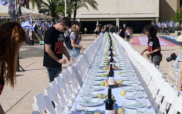 Les familles des Israéliens retenus en otage par les terroristes du Hamas à Gaza ont dressé une table symbolique de Shabbat avec de 203 sièges vides pour les otages, sur la "Place des otages", devant le Musée d'art de Tel Aviv, le 20 octobre 2023. (Crédit : Avshalom Sassoni/Flash90)