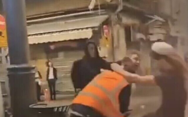 Un groupe d'hommes juifs agressant un employé arabe de la municipalité de Jérusalem au marché de Mahane Yehuda, le 20 octobre 2023. (Crédit : Capture d'écran X ; utilisée conformément à la clause 27a de la loi sur le droit d'auteur)