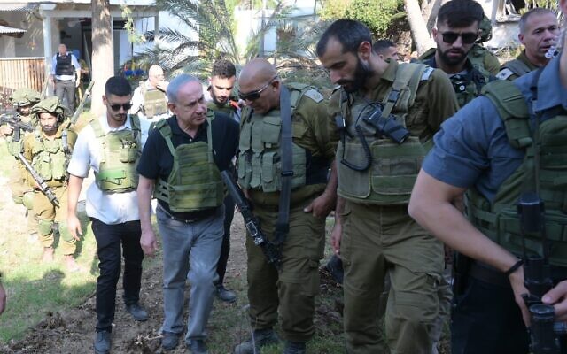 Le Premier ministre Benjamin Netanyahu s'adressant à des officiers de Tsahal dans l'une des communautés touchées par l'attaque meurtrière du Hamas, le 14 octobre 2023 (Crédit : Avi Ohayon/GPO)