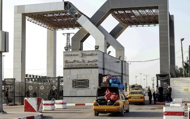 Des Palestiniens entrant en Égypte par le poste-frontière de Rafah, dans le sud de la bande de Gaza, le 15 novembre 2021. (Crédit : AFP)