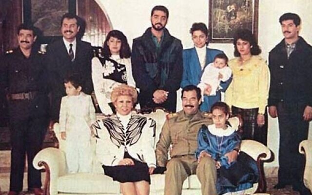 Raghad Hussein, en blazer bleu, tenant son bébé sur cette photo de la famille Saddam Hussein datant des années 1980. (Crédit : Wikimedia Commons)