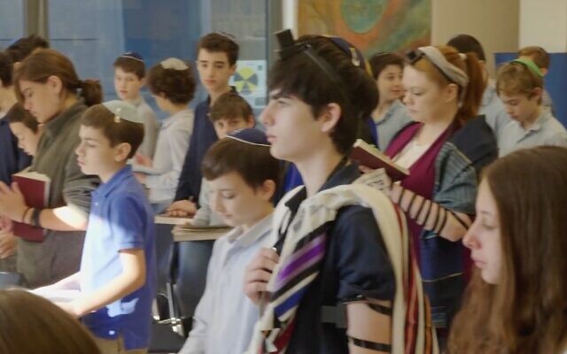 Des élèves priant à l'école Schechter Manhattan. (Crédit : Capture d'écran via JTA)