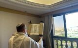 Un membre de la délégation du ministre des Communications Shlomo Karhi tient un rouleau de la Torah lors d'un office de prières matinales à Riyad, en Arabie saoudite, le 3 octobre 2023. (Crédit : Cabinet du porte-parole, ministère des Communications)