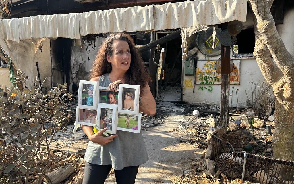 Hadas Calderon avec des photos de ses enfants dont deux sont retenus en captivité par le Hamas, au kibboutz Nir Oz, le 30 octobre 2023. (Crédit : Carrie Keller-Lynn / The Times of Israel)