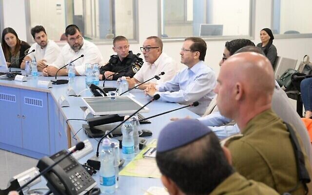 Le président Isaac Herzog (au centre à droite) lors d'une réunion du conseil municipal de Netivot, le 17 octobre 2023 (Crédit : Amos Ben Gershom / GPO)