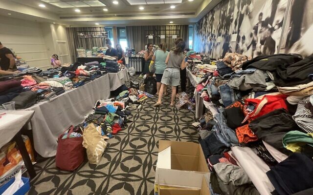 Des dons de vêtements, de jouets et d'autres articles s'empilent à l'hôtel Herod's à Tel Aviv, destiné aux personnes évacuées du kibboutz Nir Am près de la frontière de Gaza, le 9 octobre 2023. (Crédit : Sue Surkes/Times of Israël)