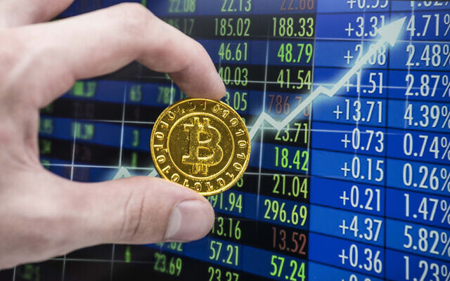 Une pièce de monnaie bitcoin dorée devant un graphique boursier. (Crédit : Getty Images) 