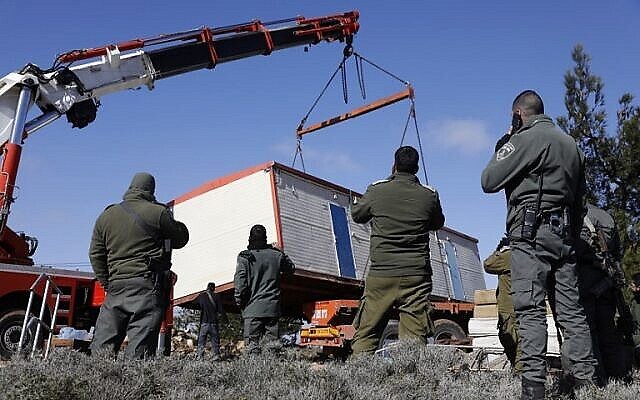 Illustration : Des membres des forces de sécurité israéliennes retirent une caravane installée par des résidents d'implantation dans l'ancien avant-poste d'Amona, le 3 janvier 2019. (Crédit : Menahem Kahana/AFP)