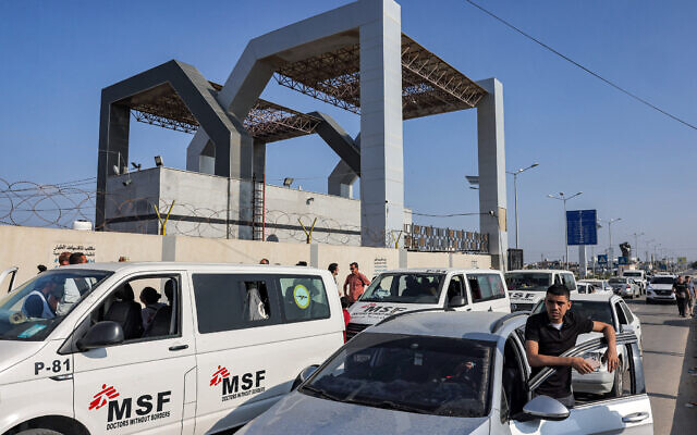 Des véhicules attendent devant la porte du poste frontière de Rafah avec l'Égypte, dans le sud de la bande de Gaza, le 1er novembre 2023. (Crédit : Mohammed ABED / AFP)