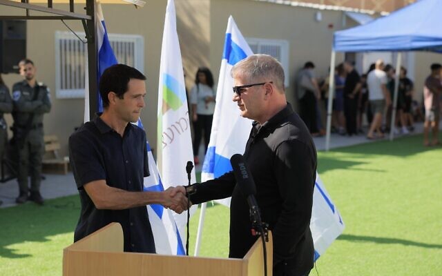 Le ministre de l'Éducation Yoav Kisch, à droite, serre la main d'Amichai Has, directeur de l'éducation du Conseil régional d'Eshkol, lors de l'ouverture d'une nouvelle école pour les évacués de la région de Gaza près de la Mer Morte, le 8 novembre 2023. (Crédit : Bureau du porte-parole du ministère de l'Éducation)