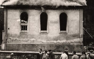 Le matin suivant la Nuit de Cristal, ou "Nuit du verre brisé", des habitants regardent la synagogue d'Ober-Ramstadt, en Allemagne, détruite par un incendie en 1938. (Crédit : CNS photo/United States Holocaust Memorial Museum)