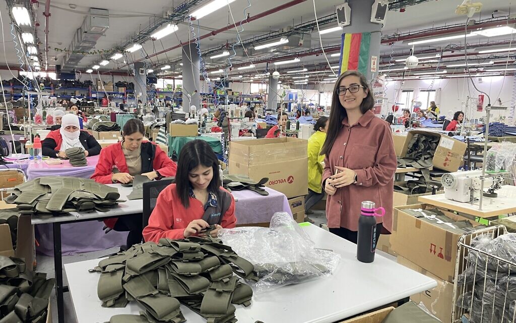 Hotaf Kablan (debout, à droite), responsable de la production, pose à côté de quelques-unes des 250 couturières druzes de l'usine Maquette Textil à Beit Jann, le 1er novembre 2023. (Crédit : Sue Surkes/Times of Israel)
