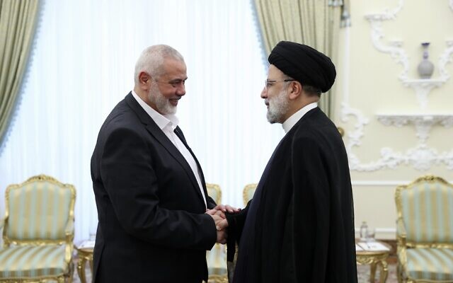 Le président iranien Ebrahim Raissi, à droite, salue le chef du groupe terroriste palestinien Hamas, Ismail Haniyeh au début de leur rencontre à son bureau à Téhéran, Iran, le 20 juin 2023. (Crédit : Bureau de la présidence iranienne/AP)