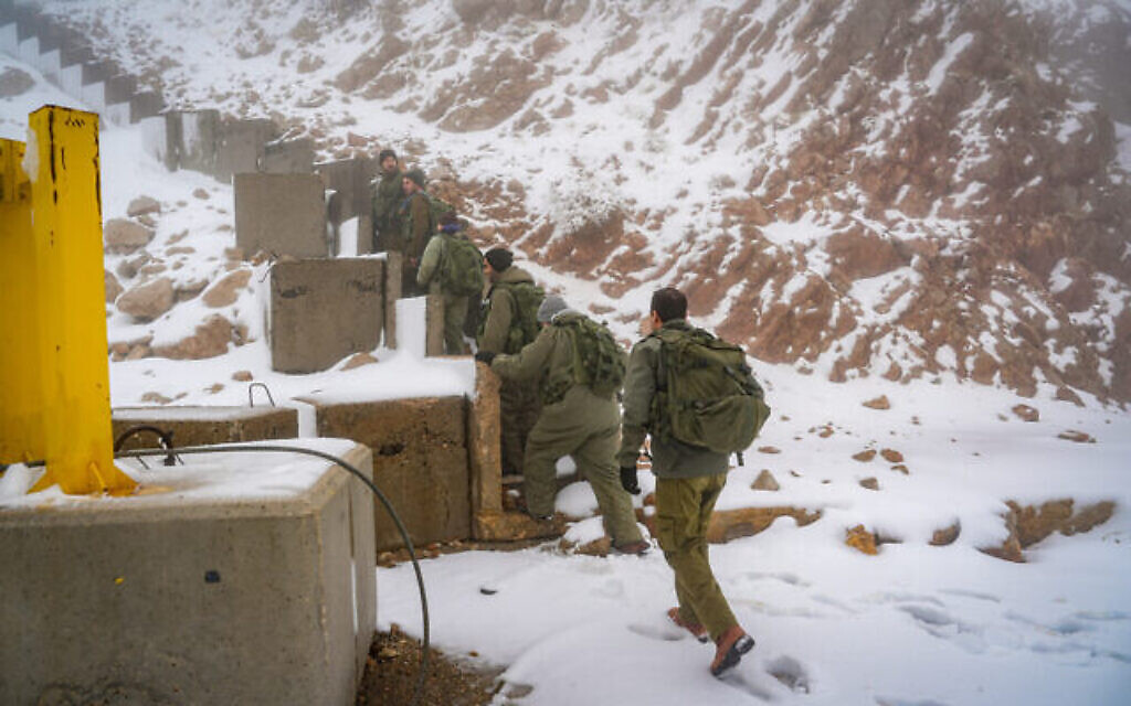 Des soldats israéliens patrouillent dans la neige sur le mont Hermon, près de la frontière israélienne avec le Liban, dans le nord d'Israël, le 20 novembre 2023. (Crédit : Ayal Margolin/Flash90)