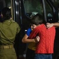 Libéré par le Hamas, Eitan Yahalomi serre sa mère dans ses bras après avoir débarqué de l'hélicoptère, le 27 novembre 2023 (Crédit : Armée israélienne)