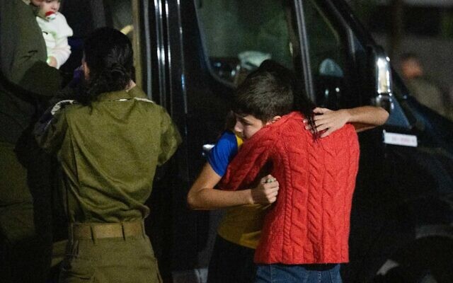 Libéré par le Hamas, Eitan Yahalomi serre sa mère dans ses bras après avoir débarqué de l'hélicoptère, le 27 novembre 2023 (Crédit : Armée israélienne)
