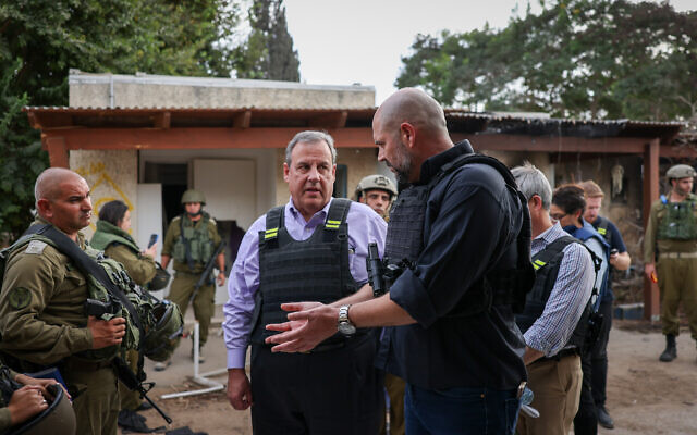 Le candidat républicain à la présidence des États-Unis, Chris Christie, au centre, s'entretenant avec le président de la Knesset Amir Ohana, à droite, lors d'une visite des ruines du kibboutz Kfar Azza, le 12 novembre 2023. (Crédit : Noam Moskowitz/Porte-parole de la Knesset)