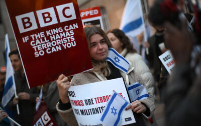 Des manifestants brandissant des pancartes et drapeaux israéliens à un rassemblement devant le siège de la BBC (British Broadcasting Corporation) à Londres, le 16 octobre 2023, pour tenter de la convaincre de qualifier le Hamas de « terroriste ». (Crédit : Daniel Leal / AFP)