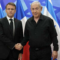 Le Premier ministre Benjamin Netanyahu, à droite, saluant le président français Emmanuel Macron avant une réunion à Jérusalem, le 24 octobre 2023. (Crédit :  Ena/POOL/AFP)